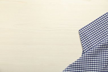 Beyaz ahşap zemin üzerinde kareli masa örtüsü, üst manzara. Metin için boşluk