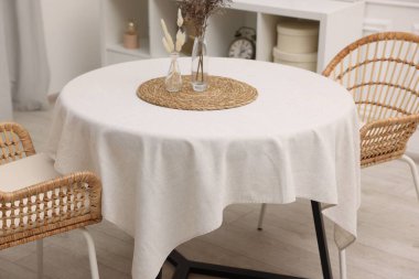 Beyaz masa örtülü masa, vazolarda kurumuş çiçekler ve şık odalarda sandalyeler. İç tasarım