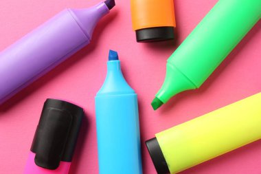 Pembe arka planda parlak ışıklandırıcılar, düz yatış