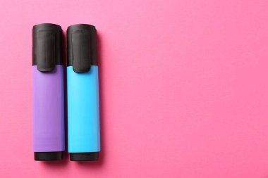 Pembe arka planda parlak fosforlu kalemler, düz yatış. Metin için boşluk