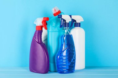 Açık mavi ahşap masada farklı temizlik ürünleri