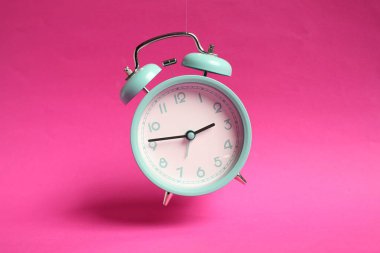 Turkuaz çalar saat açık pembe arka planda