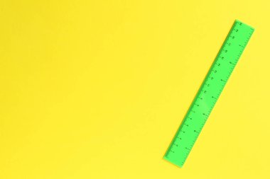 Sarı arka planda bir yeşil cetvel, üst manzara. Metin için boşluk