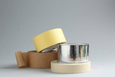 Gri arkaplanda farklı yapışkan bantların ruloları