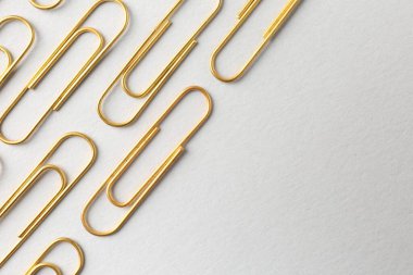 Arka planda altın ataçlar, düz yatış. Metin için boşluk