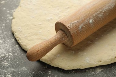 Taze hamur ve merdane gri masada, yakın plan.