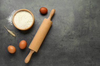 Yuvarlanan iğne, bir kase un, yumurta ve çivi gri masada, düz yerde. Metin için boşluk