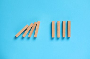 Domino etkisi. Açık mavi zemin üzerinde ahşap bloklar, düz yatıyordu