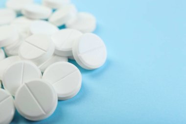 Açık mavi arka planda bir sürü antibiyotik hapı var. Yakın plan. Metin için boşluk