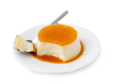 Karamel soslu lezzetli puding ve beyaz üzerine izole edilmiş kaşık.