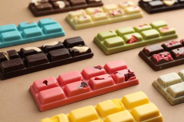 Bej arka planda farklı lezzetli çikolatalar, yakın plan.