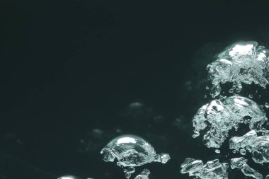 Karanlık arka planda bir sürü su kabarcığı, yakın plan. Metin için boşluk