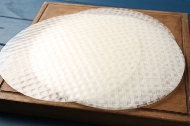 Mavi ahşap masadaki yenilebilir pirinç kağıtları, yakın plan.