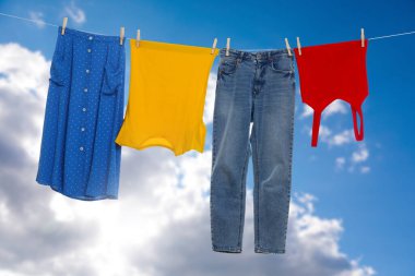 Different clothes drying on washing line against blue sky