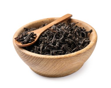 Kuru çay yaprakları kasede ve kaşıklar beyazda izole edilmiş.