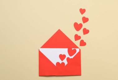 Sevgililer Günü. Bej arka planda birçok kağıt kalpli zarf, üst görünüm