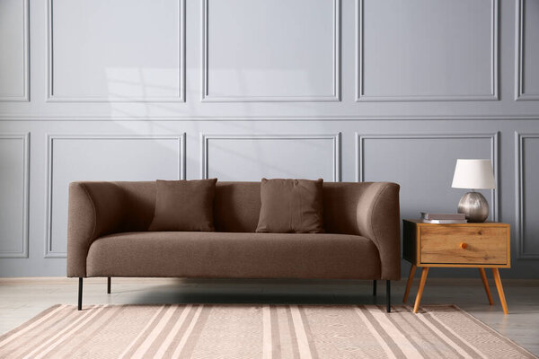 Sofa in mocha mousse shade indoors. Cozy interior with trendy color of 2025 year