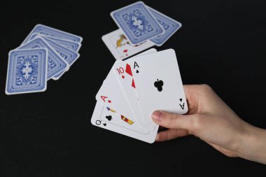 Siyah masada kağıt oynayan kadın, yakın plan.