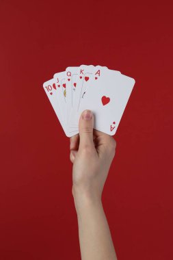 Kırmızı arkaplanda oyun kartları olan kadın, yakın plan