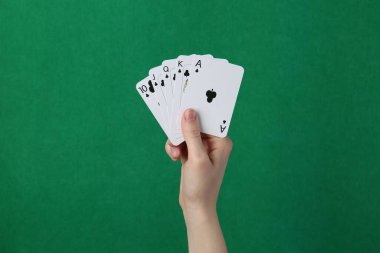 Yeşil arka planda kart oynayan kadın, yakın plan