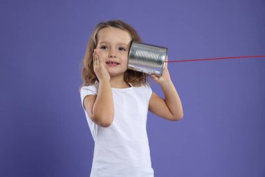 Menekşe arkaplanda teneke telefon kullanan kız