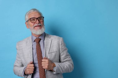 Açık mavi arka planda gri sakallı yaşlı adamın portresi. Metin için boşluk