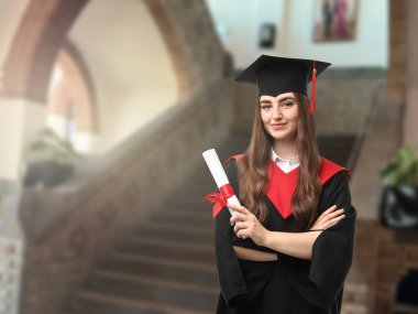 Üniversiteden mezun olduktan sonra elinde diploması olan mutlu bir öğrenci.