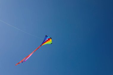 Mavi gökyüzünde uçan renkli bir uçurtma. Metin için boşluk