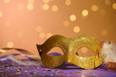 Renkli arka planda güzel bir karnaval maskesi, kurdeleler ve konfeti, bulanık ışıklar, yakın plan