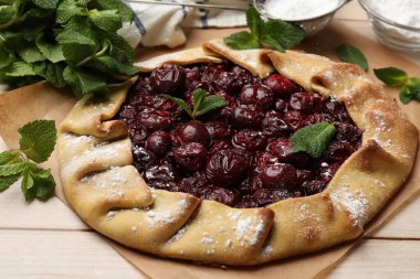 Kirazlı, nane ve pudra şekerli lezzetli galet ahşap masada, yakın plan.