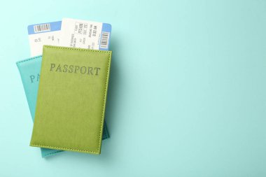 Açık mavi arka planda biletleri olan pasaportlar, üst manzara. Metin için boşluk