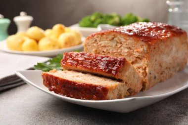 Gri masada servis edilen lezzetli fırınlanmış hindi köftesi, yakın plan.
