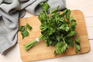 Bir demet taze maydanoz ve açık ahşap masa üzerinde yapraklar, üst manzara