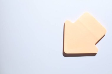 Beyaz arka planda bir tane turuncu kağıt ok, üst manzara. Metin için boşluk