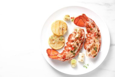 Lezzetli ıstakoz kuyruğu, limon, mikroyeşillik ve yeşil soğan, beyaz masa, üst manzara. Metin için boşluk