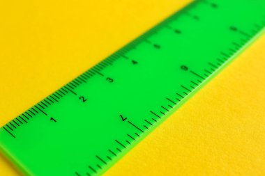 Sarı arka planda bir yeşil cetvel, yakın plan.