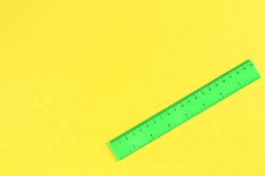 Sarı arka planda bir yeşil cetvel, üst manzara. Metin için boşluk