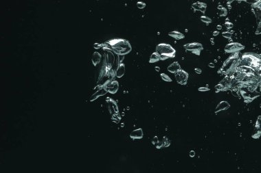 Siyah arka planda bir sürü su kabarcığı var, yakın plan. Metin için boşluk