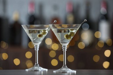 Arkaplanda bulanık arka planda zeytinli martini kokteyli. Bokeh etkisi