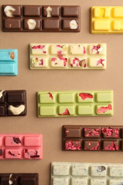 Bej arka planda farklı lezzetli çikolatalar, düz yatış.