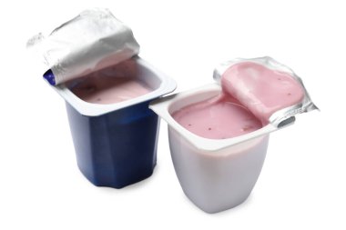Plastik bardaklardaki lezzetli yoğurtlar beyaza izole edilmiş.