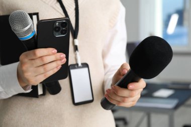 Mikrofonlu, akıllı telefonlu ve defterli bir gazeteci.
