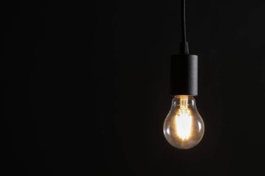 Karanlık arka planda parlayan ampul. Metin için boşluk