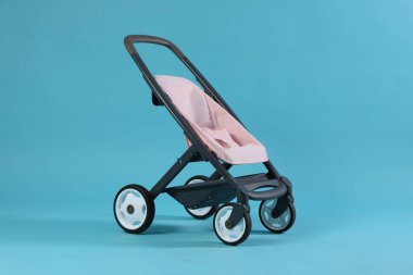 Açık mavi arka planda bebek arabası. Çocuk oyuncağı.