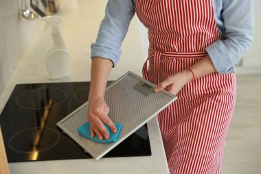 Mutfak kaputunun filtresi kapalı alanda paçavrayla temizleniyor.