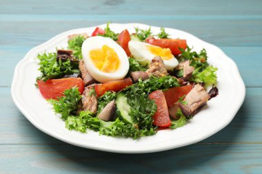 Açık mavi ahşap masada nefis taze ton balığı salatası, yakın plan.