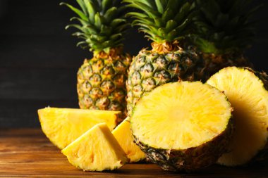 Ahşap masa üzerinde tüm ve kesme olgun ananas