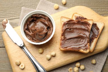 Çikolata tereyağlı sandviçler, fındıklı fındıklar ve tahta masada bıçak, düz uzanma