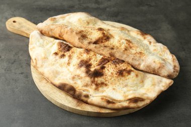 Gri desenli masada leziz calzone 'lar, yakın plan.