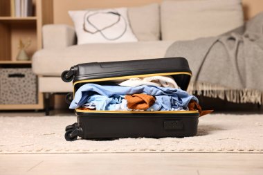 İçerde farklı kıyafetlerle dolu bir bavul aç.